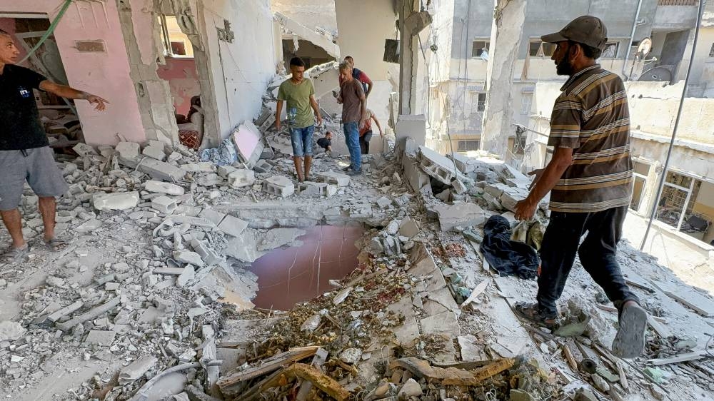 Palestinians inspect the site of an Israeli strike on a house in Gaza City Monday. REUTERS