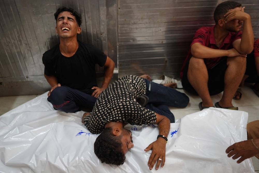 Palestinians mourn over a body of a relative, killed in an Israeli strike, ahead of their funeral in Khan Yunis in the southern Gaza Strip on Monday. AFP