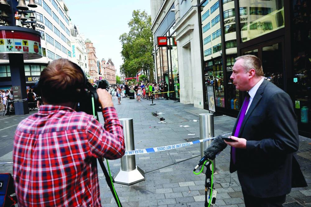 Members of the media standing outside a cordoned off area in Leicester square.