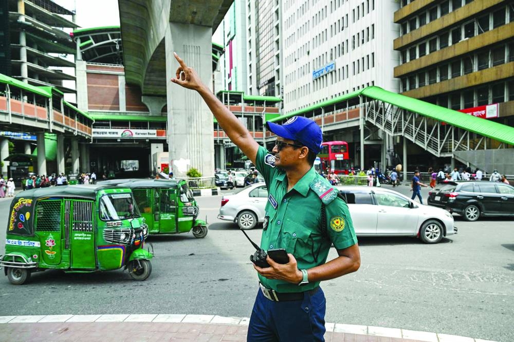 A police personnel controls traffic at a road intersection after the Bangladeshi police force resumed duty, in Dhaka yesterday. Bangladeshi police resumed patrols of the capital Dhaka on Monday, ending a week-long strike that left a law and order vacuum following the abrupt ouster of autocratic ex-premier Sheikh Hasina.