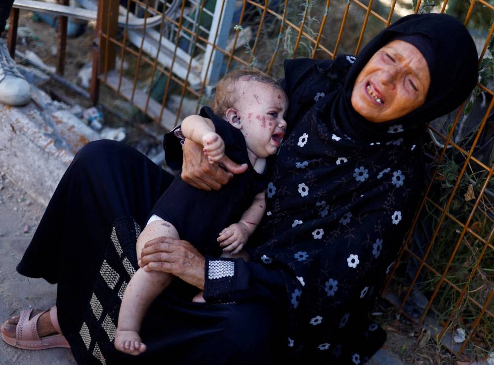 Reem Abu Haya, a Palestinian girl who survived an Israeli strike that killed her entire family, cries as she is held by a relative at Nasser hospital, in Khan Younis in the southern Gaza Strip on Tuesday. REUTERS