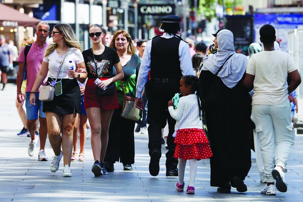 
A police officer walks amongst crowds at Leicester Square, in London. 