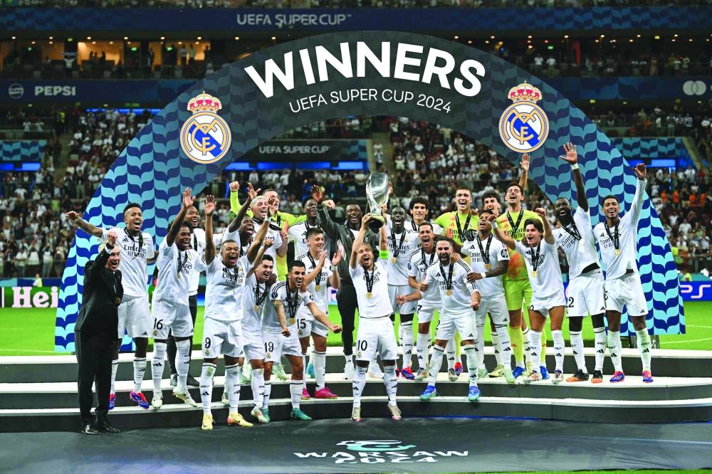 Real Madrid players celebrate with the trophy after winning the UEFA Super Cup match against Atalanta in Warsaw, Poland, on Wednesday. (AFP) 