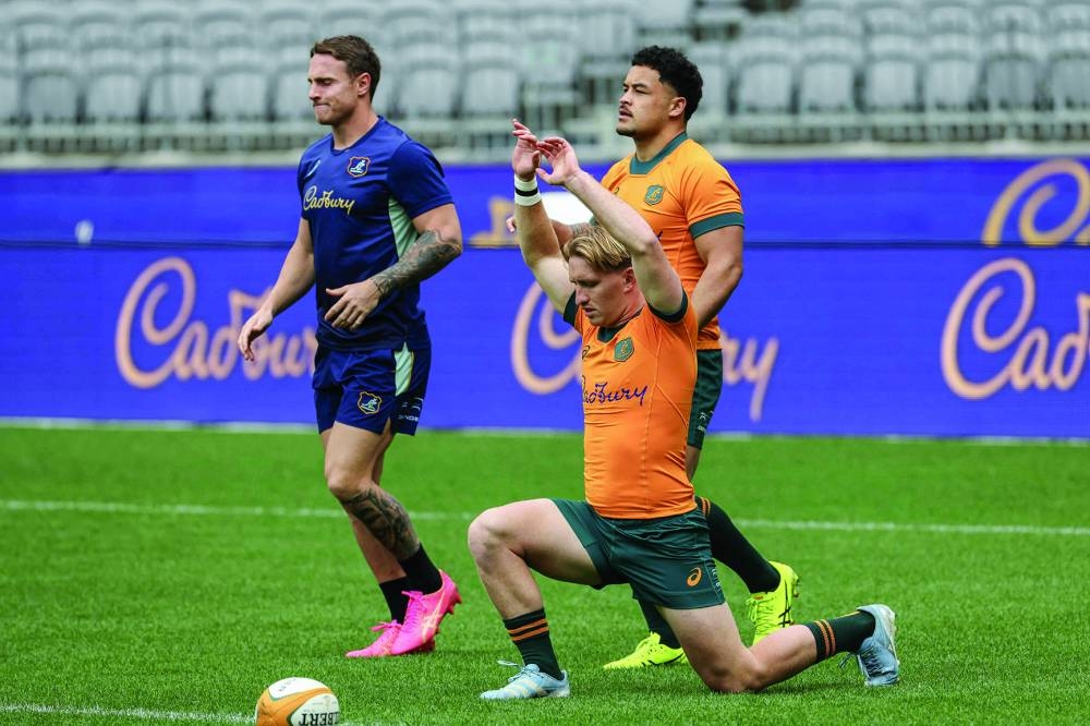 Australia’s Tate McDermott (front), Hunter Paisami (right) and Corey Toole stretch during their team’s captain’s run on Friday in Perth ahead of their Rugby Championship match against South Africa. (AFP) 