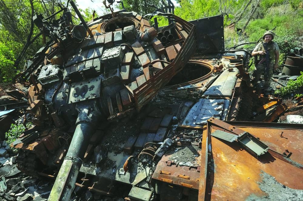 A Ukrainian serviceman is seen near a destroyed tank in Ukraine’s Donetsk region. – Reuters