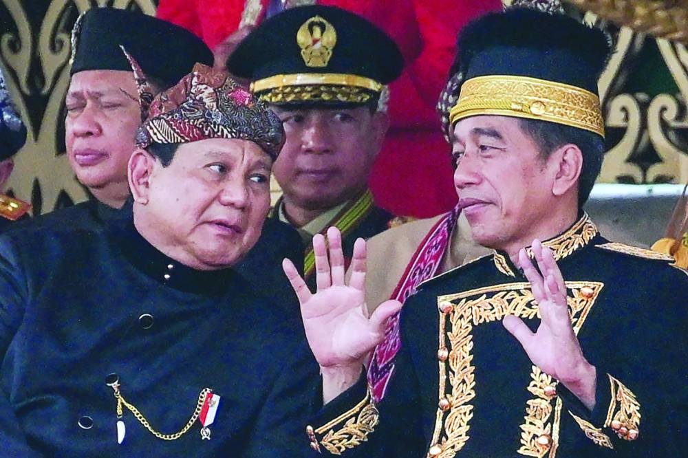 Indonesian President Joko Widodo talks to President-elect Prabowo Subianto following a flag-raising ceremony marking Indonesia’s 79th Independence Day at the presidential palace 
in the future capital Nusantara.
