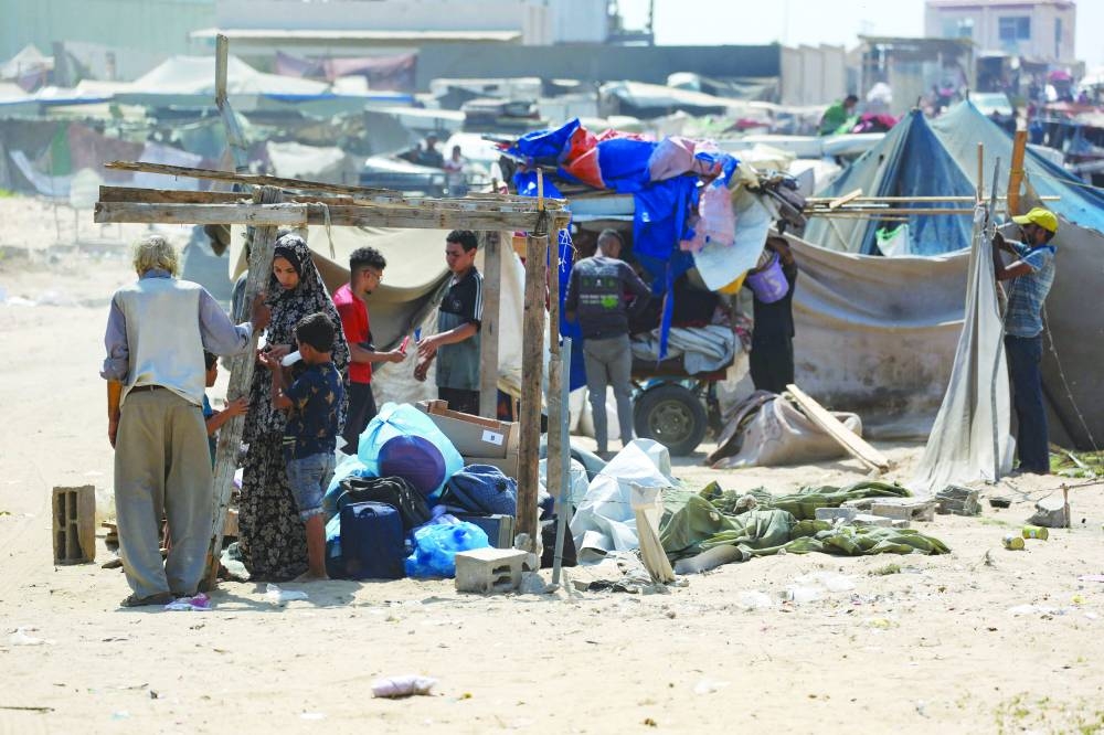 Palestinians dismantle their tent as they prepare to flee a makeshift camp for displaced people in Khan Younis in the southern Gaza Strip after Israeli tanks took position on a hill overlooking the area on Sunday 