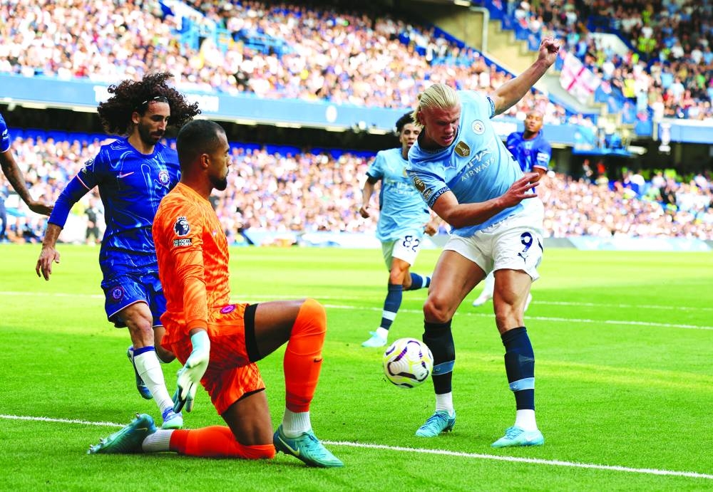 
Erling Haaland dinks the ball past Robert Sanchez to open the scoring for Manchester City. (Reuters) 