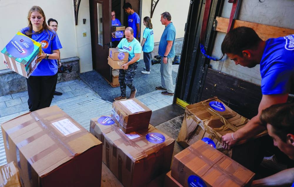 
Volunteers load a truck with humanitarian aid intended for residents of the Kursk region, which was affected by an incursion of Ukrainian troops in the course of Russia-Ukraine conflict, in Moscow. Signs on boxes and volunteers’ T-shirts read: “Moscow helps”. (Reuters) 