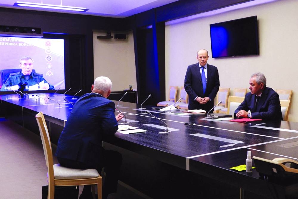 
Director of the Federal Security Service (FSB) Alexander Bortnikov, Security Council’s Secretary Sergei Shoigu and Defence Minister Andrei Belousov attend a meeting with Russian President Vladimir Putin (unseen) on the Ukrainian incursion into Russia’s Kursk Region, while Chief of the General Staff of Russian Armed Forces Valery Gerasimov is seen on a screen, outside Moscow, on August 7, 2024. (Reuters) 