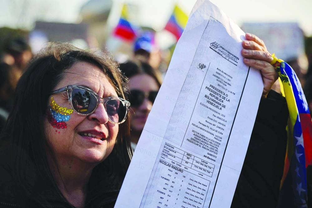 A woman shows a copy of a voting record during a protest in Buenos Aires called by the Venezuelan opposition. – AFP