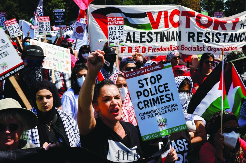 People hold signs and flags in support of Palestinians in Gaza as demonstrators rally on the sidelines of the Democratic National Convention (DNC) in Chicago, Illinois, U.S.,on Monday 
