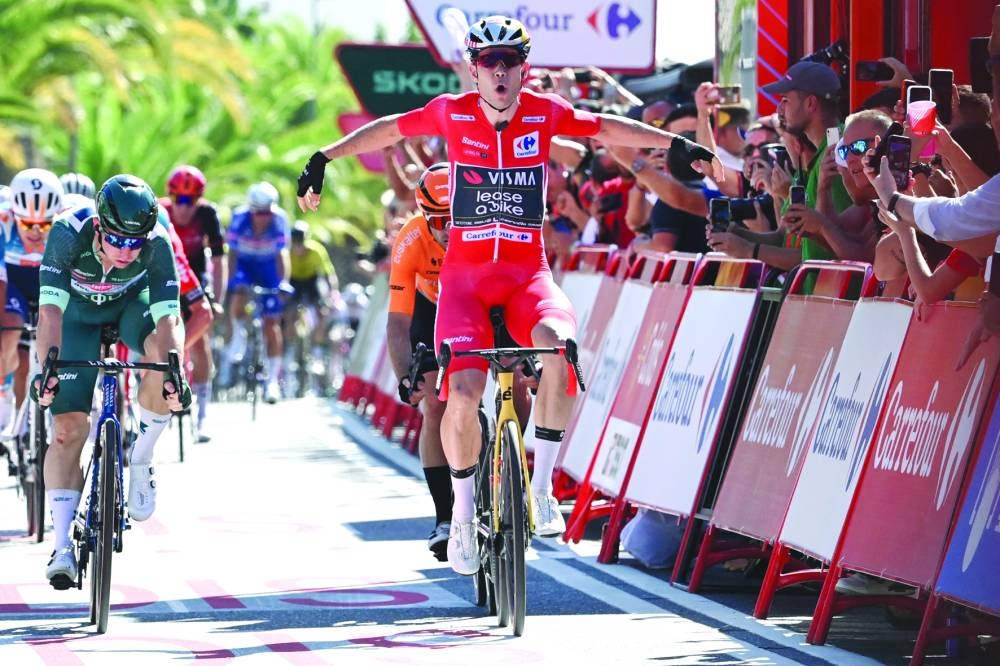 General ranking leader Team Visma’s Wout van Aert (right) celebrates as he crosses the finish line followed by Team Alpecin’s Kaden Groves (left) and Team Euskaltel-Euskadi’s Jon Aberasturi (2R) during the stage 3 of La Vuelta a Espana cycling tour, a 191.2km race between Lousa and Castelo Branco, on Monday. (AFP)