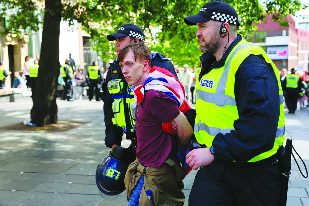 An anti-immigration protester is detained by police officers, in Newcastle, Britain. 