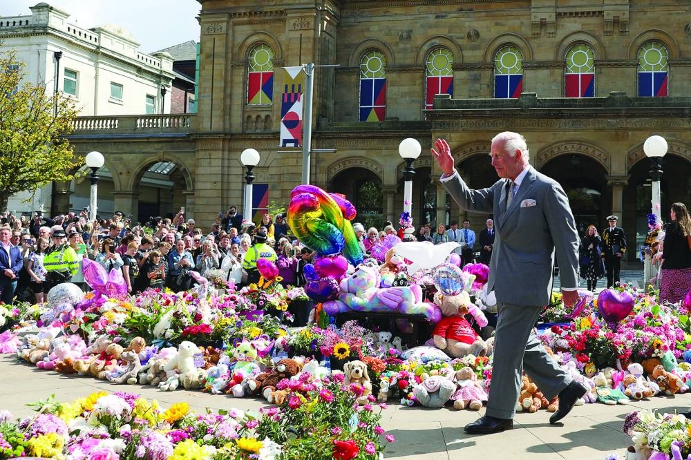 Britain’s King Charles gestures, as he makes a community visit, outside the Town Hall in Southport.