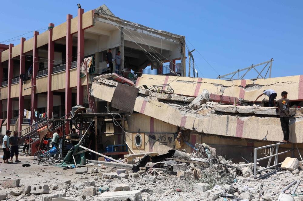 People inspect the damage after an Israeli strike on a school, housing displaced Palestinians, in the Rimal neighbourhood of central Gaza City on on Tuesday. AFP