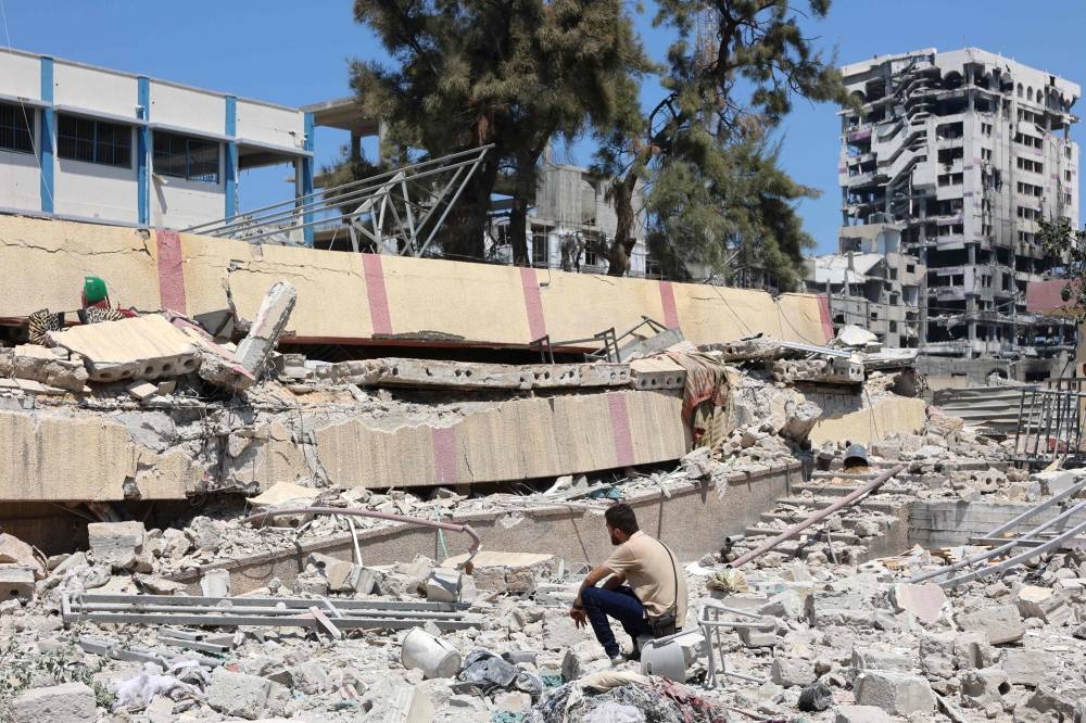 A man looks at the debris after an Israeli strike on a school, housing displaced Palestinians, in the Rimal neighbourhood of central Gaza City on Tuesday. AFP