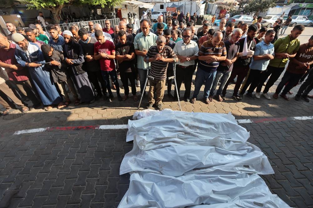 Mourners react next to the bodies of Palestinians killed in Israeli strikes, at Al-Aqsa Martyrs Hospital in Deir Al-Balah in the central Gaza Strip, Tuesday. REUTERS