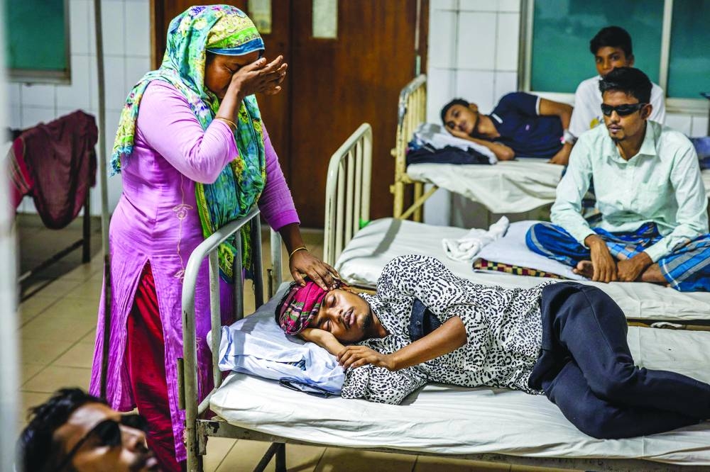 
A woman weeps as her son rests in a bed at National Institute of Ophthalmology and Hospital in Dhaka. 