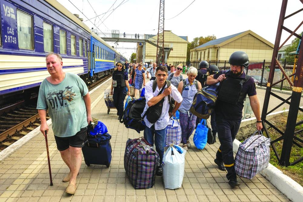 Local residents approach an evacuation train as they flee Russian troop advances in Pokrovsk, Ukraine, yesterday. (Reuters)