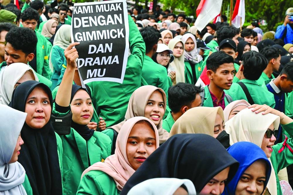 
University students hold a poster reading “We are fed up with your tricks and drama” during a protest in Banda Aceh. 