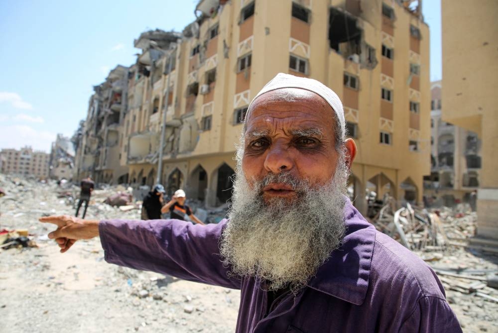 A man gestures as Palestinians inspect damage in Hamad City, following an Israeli raid, in Khan Younis, in the southern Gaza Strip, on Saturday. REUTERS