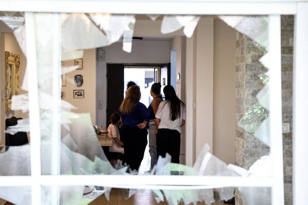 Residents check the damage caused by a strike from Lebanon in the Israeli coastal town of Acre on Sunday. AFP
