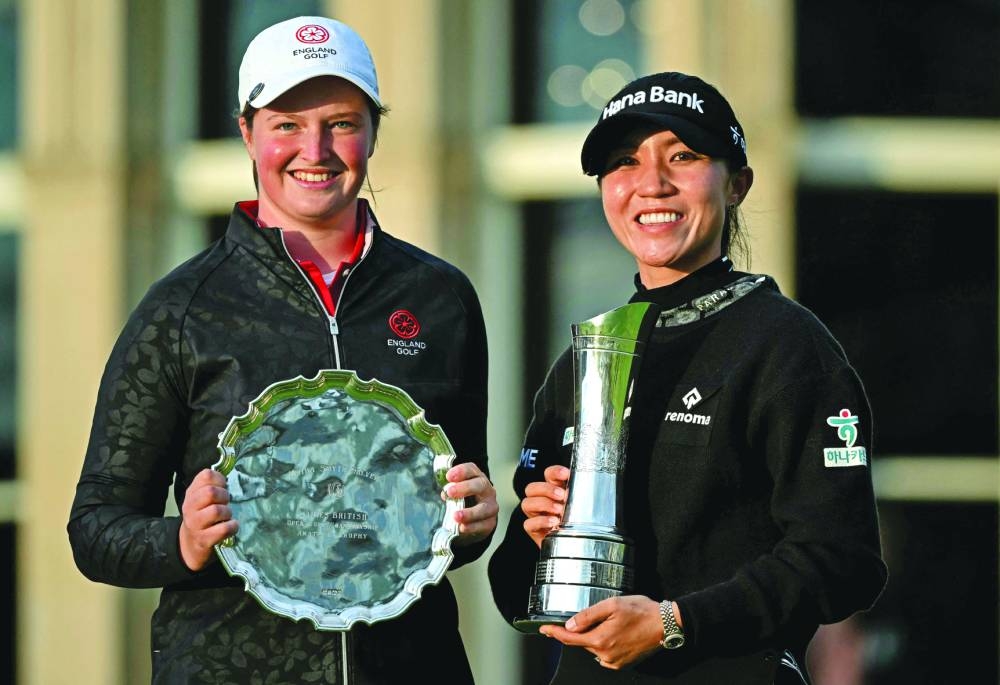 England’s Lottie Woad (left) and New Zeland’s Lydia Ko pose with their trophies on day four of the 2024 Women’s British Open Golf Championship, on the Old Course at St Andrews, in St Andrews, Scotland, on Sunday. (AFP)
