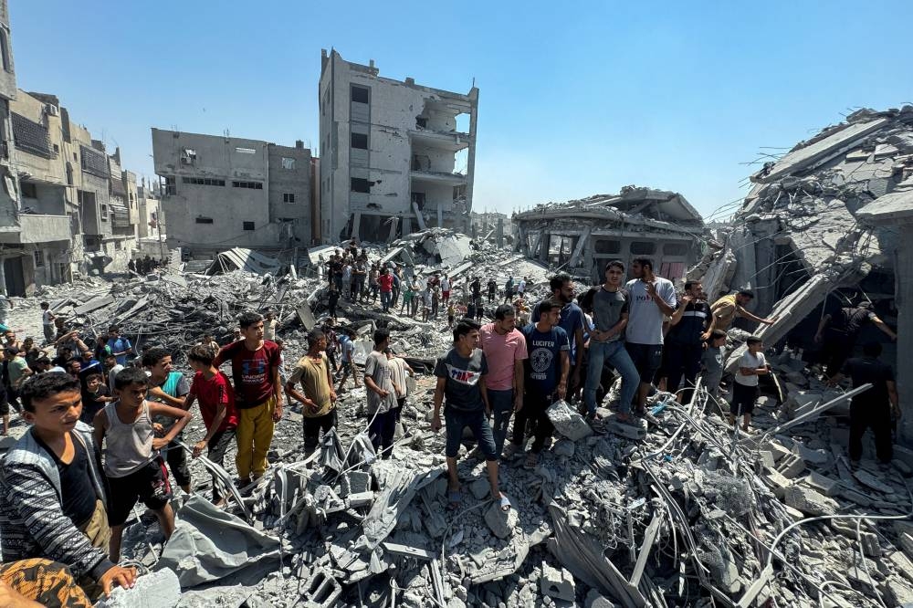 Palestinians gather at the site of an Israeli strike that destroyed several houses in Khan Younis in the southern Gaza Strip on Tuesday. REUTERS