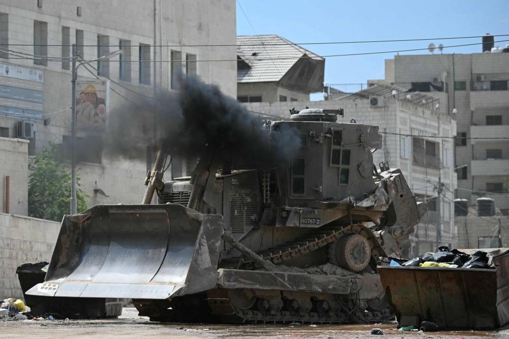 An Israeli military bulldozer drives down a road during a raid in Jenin in the occupied West Bank on Wednesday. AFP