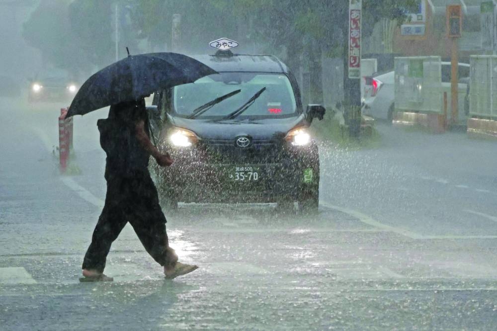 
A passerby walking in heavy rains caused by Typhoon Shanshan in Miyazaki, southwestern Japan. 