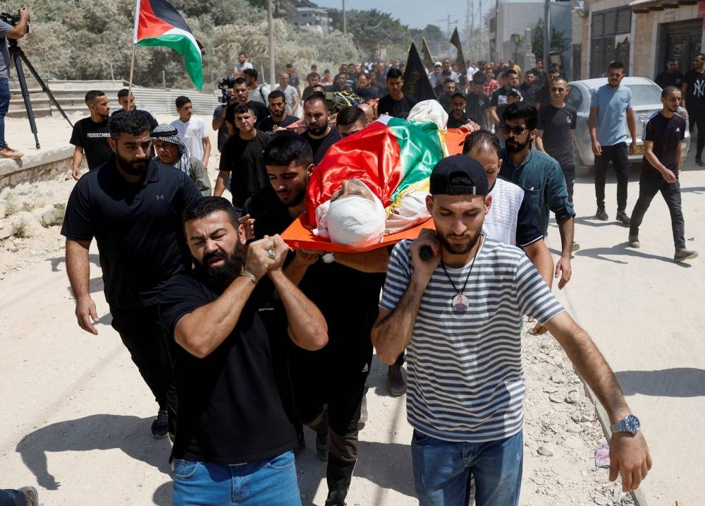 Mourners carry the body of a Palestinian who was killed by Israeli forces, during his funeral in Nur Shams refugee camp, near Tulkarm in the Israeli-occupied West Bank, on Friday. REUTERS