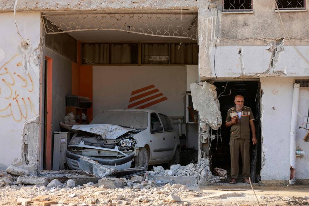 A Palestinian man holds a cup of tea amid the devastation in the the Nur Shams refugee camp near Tulkarem in the occupied-West Bank following a large-scale military operation on Friday. AFP