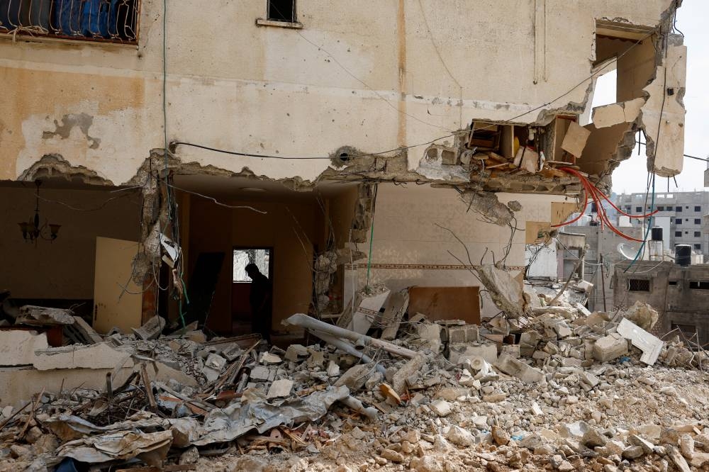 A Palestinian man inspects the damage in a house, following an Israeli military raid, in Tulkarm, in the Israeli-occupied West Bank, on Friday. REUTERS
