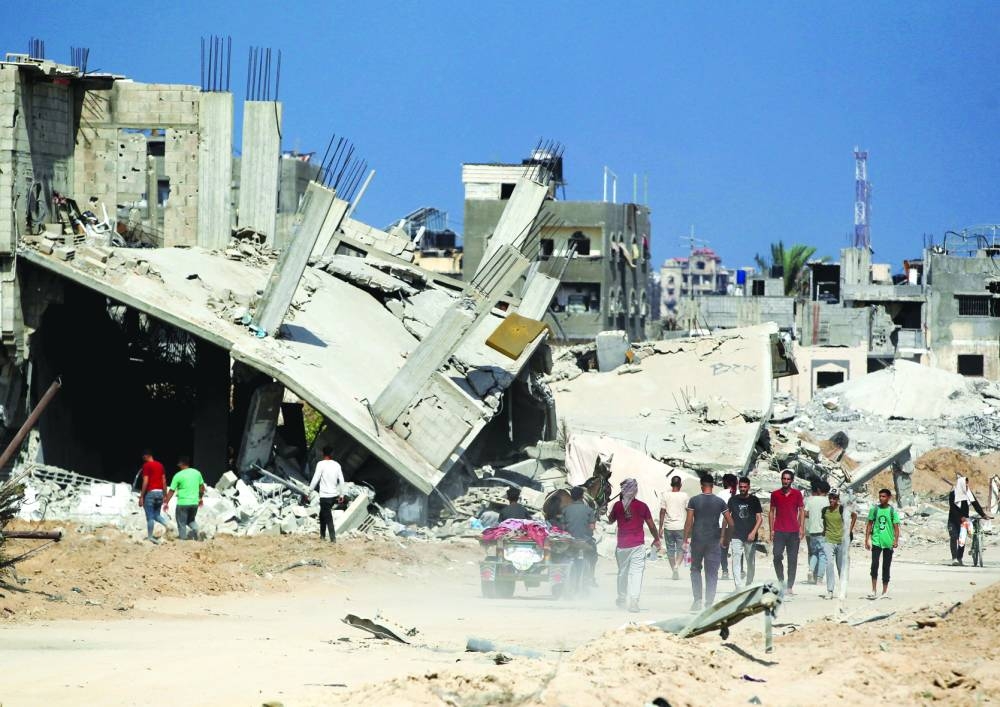Palestinians walk near rubble, after Israeli forces withdrew from the area, following a ground operation in Khan Younis, in the southern Gaza Strip, Friday.