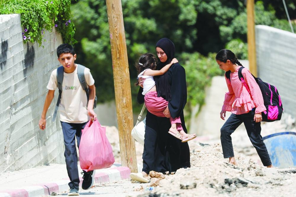 
Palestinians walk, as they evacuate their home during an Israeli raid in Jenin camp, in the occupied West Bank. 