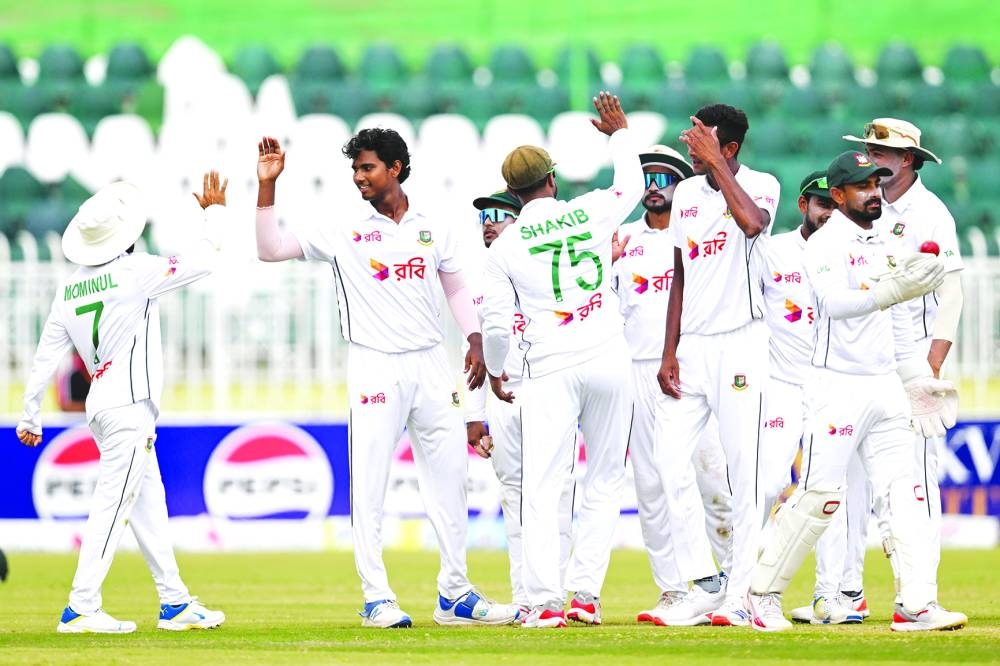 Bangladesh’s Hasan Mahmud (second left) celebrates with teammates after taking the wicket of Pakistan’s Mohamed Rizwan at the Rawalpindi Cricket Stadium on Monday. (AFP)