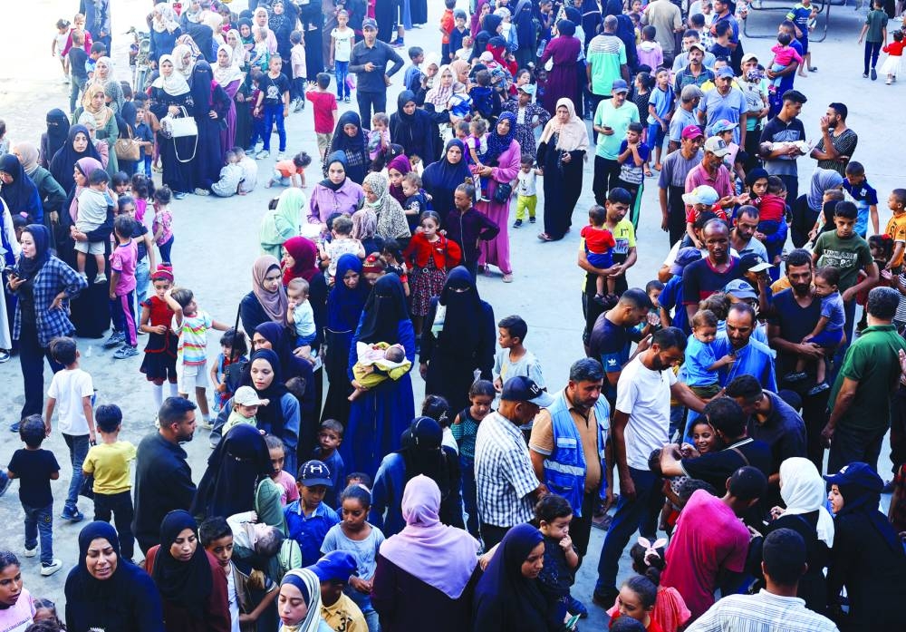 
People queue as Palestinian children are vaccinated against polio in Khan Younis in the southern Gaza Strip yesterday. 