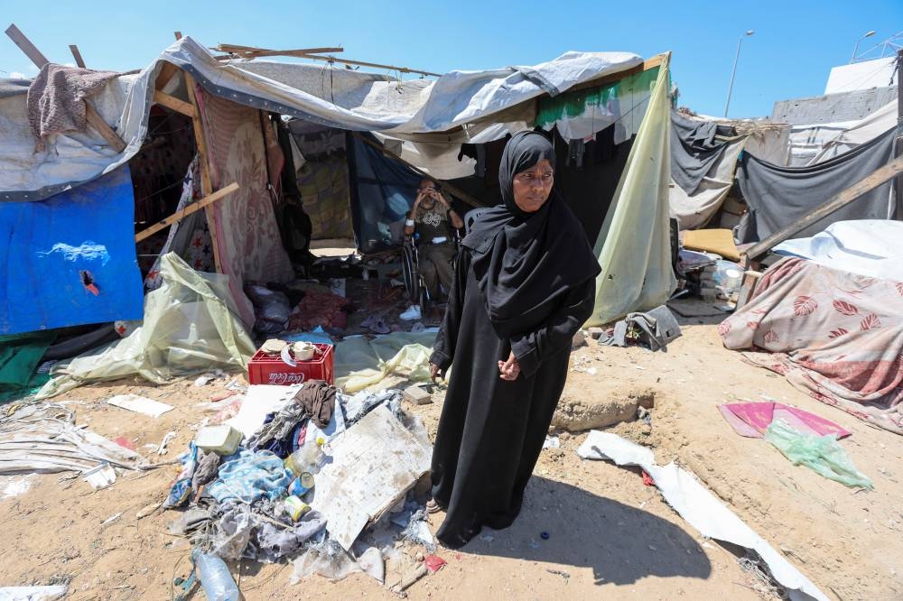 Displaced woman Iqbal Al-Zeidi stands in front of her tent which was torn by an Israeli strike, on the courtyard of Al-Aqsa Martyrs hospital, in Deir Al-Balah in the central Gaza Strip, on Thursday. REUTERS