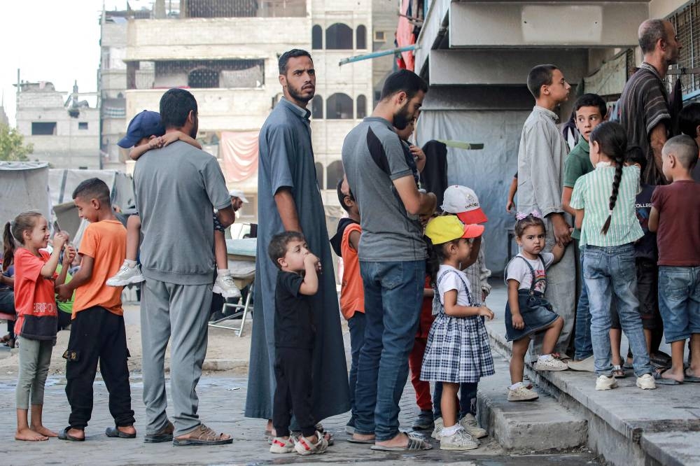 People queue with children for polio vaccinations in Khan Yunis in the southern Gaza Strip on Thursday. AFP