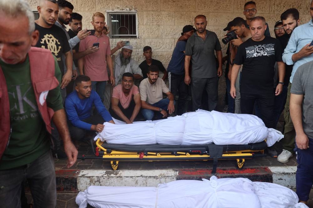 Palestinians mourn over the bodies of victims of Israeli bombardment on Saturday in Deir el-Balah in the central Gaza Strip. AFP
