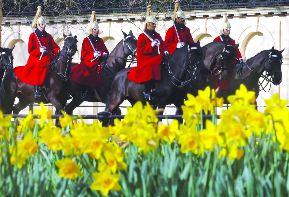 Daffodils bloom in St James’s Park as members of the Household Cavalry ride along The Mall in London.