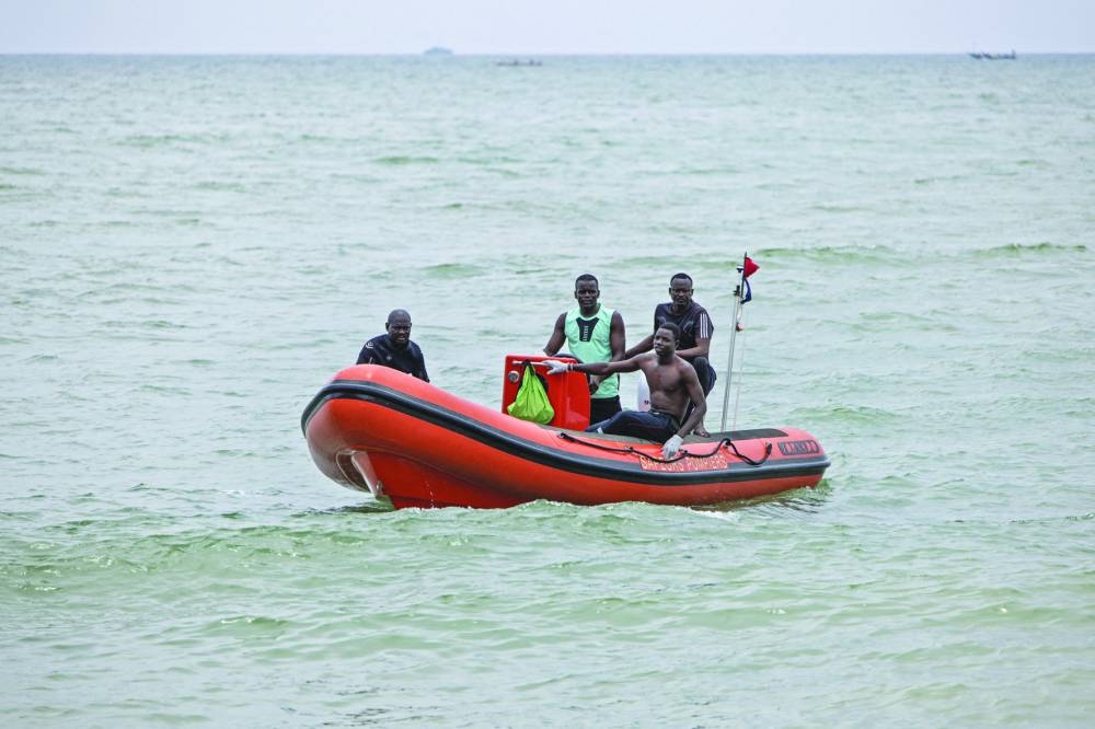 Members of a search and rescue team make their way to shore during a search to find survivors and to retrieve the dead after a pirogue carrying over a hundred migrants sank, in Mbour, yesterday.