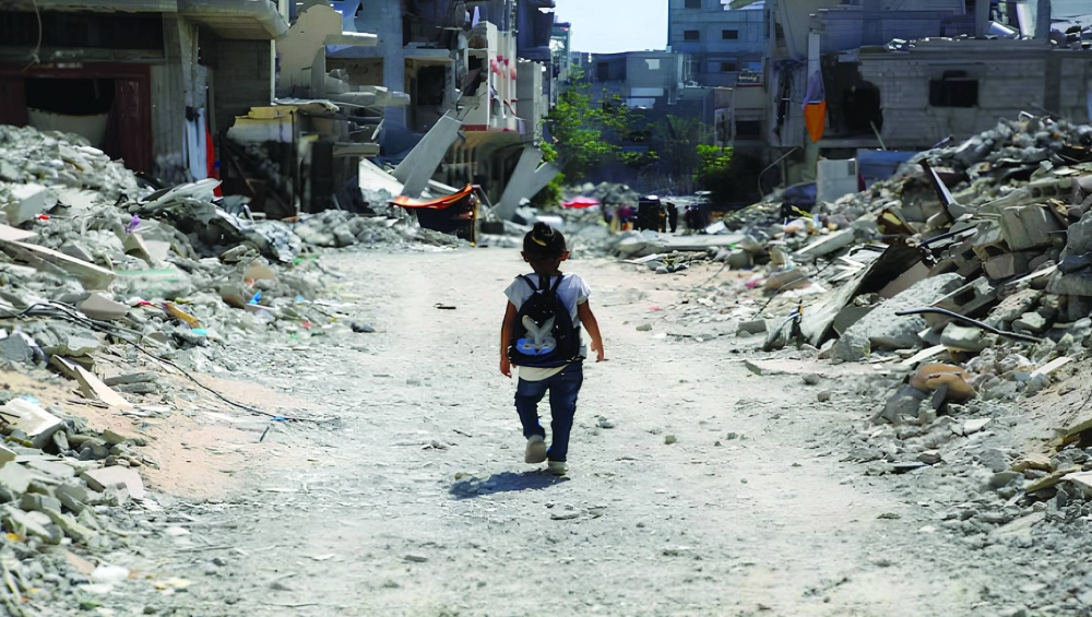 File photo shows a Palestinian student walk between the rubble, as war disrupts a new school year, amid the Israel-Hamas conflict, in Khan Younis, in the southern Gaza Strip.