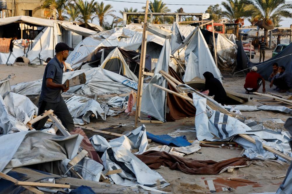 Palestinians inspect the site following Israeli strikes on a tent camp sheltering displaced people, at the Al-Mawasi area in Khan Younis, in the southern Gaza Strip, on Tuesday. REUTERS