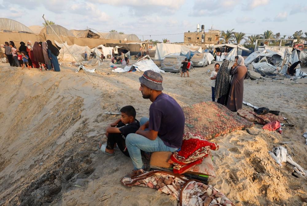 Palestinians inspect the site following Israeli strikes on a tent camp sheltering displaced people at the Al-Mawasi area in Khan Younis, in the southern Gaza Strip, on Tuesday. REUTERS