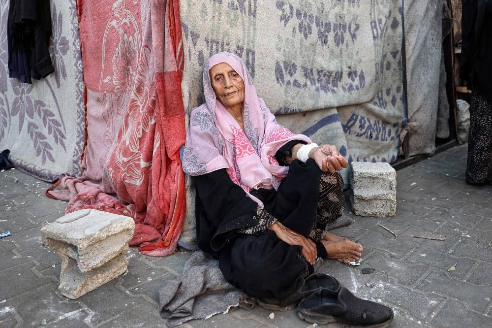 An elderly Palestinian woman sits at a school sheltering displaced people, in Nuseirat in the central Gaza Strip on Wednesday. AFP