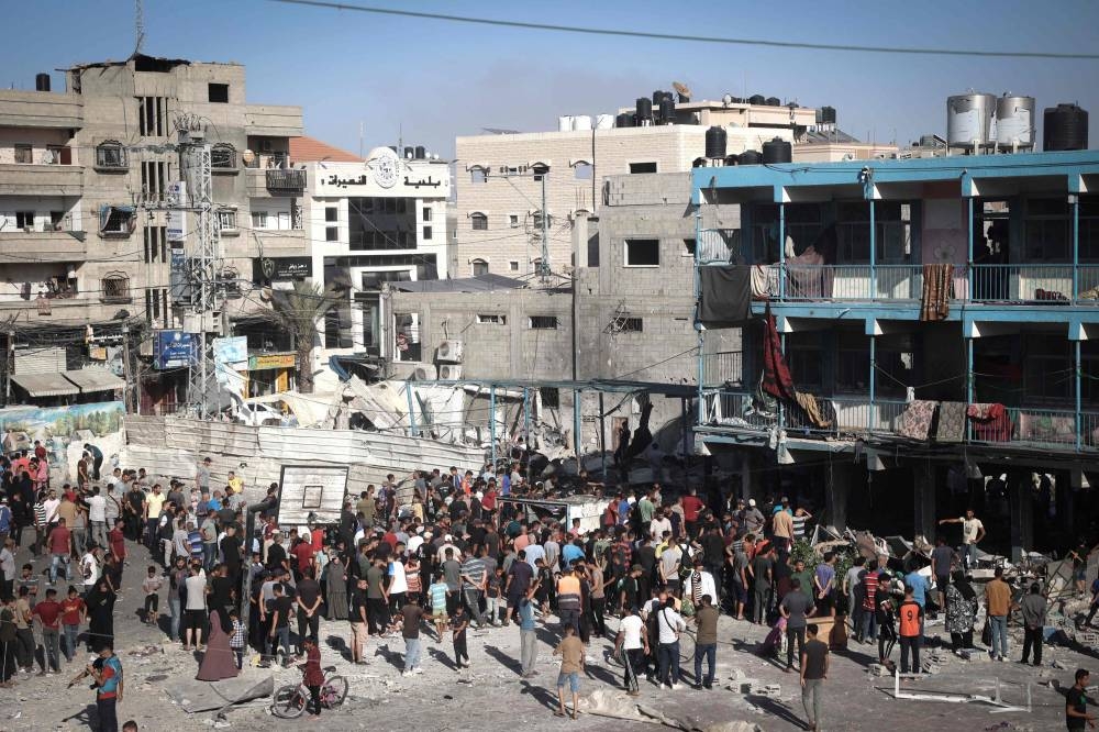 Palestinians stand in the courtyard of a school after an Israeli air strike hit the site, in Nuseirat in the central Gaza Strip on on Wednesday. AFP