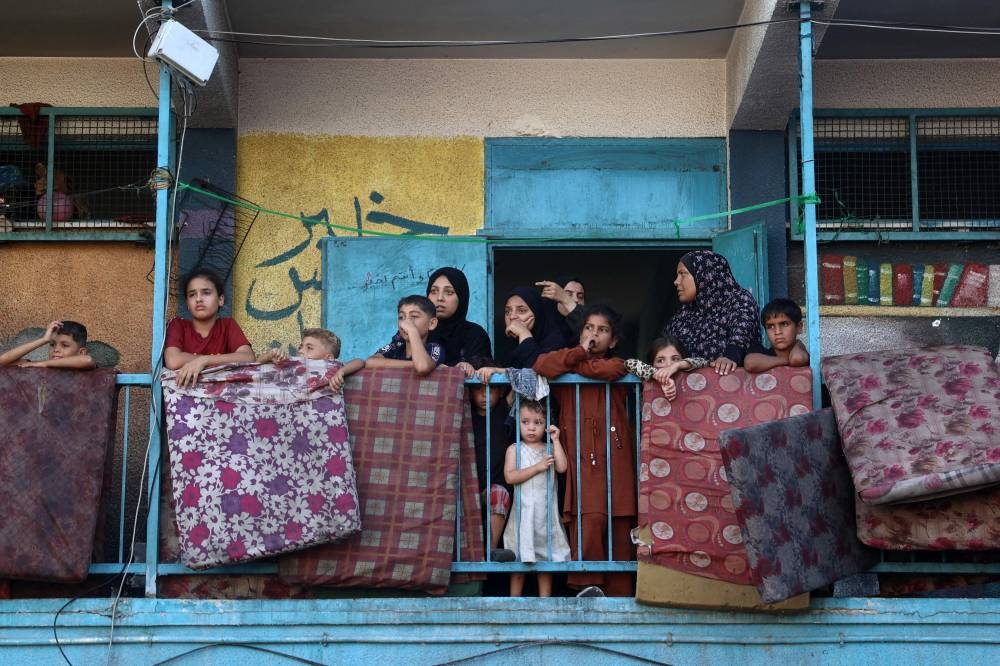 Displaced Palestinians taking shelter at a UN school watch after an Israeli air strike hit the site, in Nuseirat in the central Gaza Strip on Wednesday. AFP