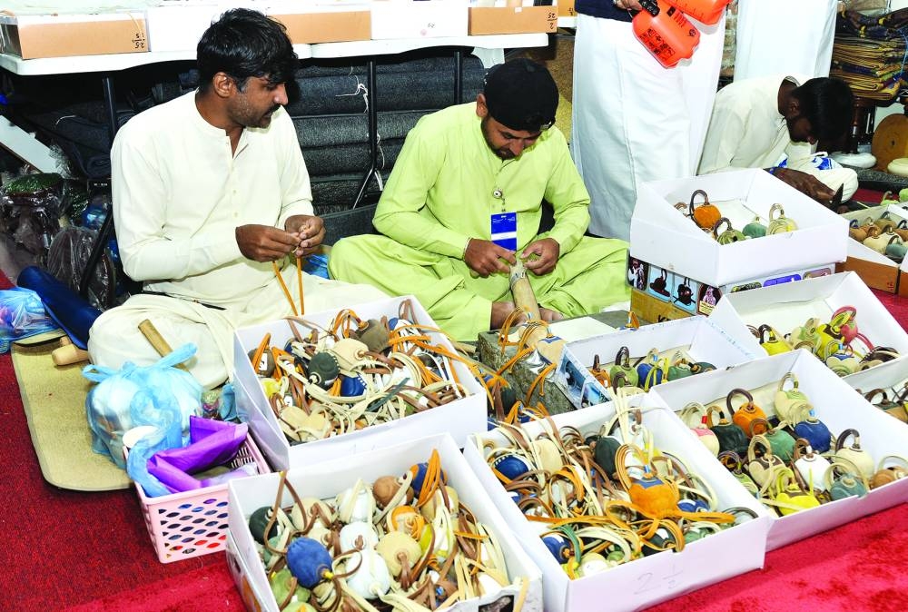 Craftsmen making falcon hoods at the exhibition.